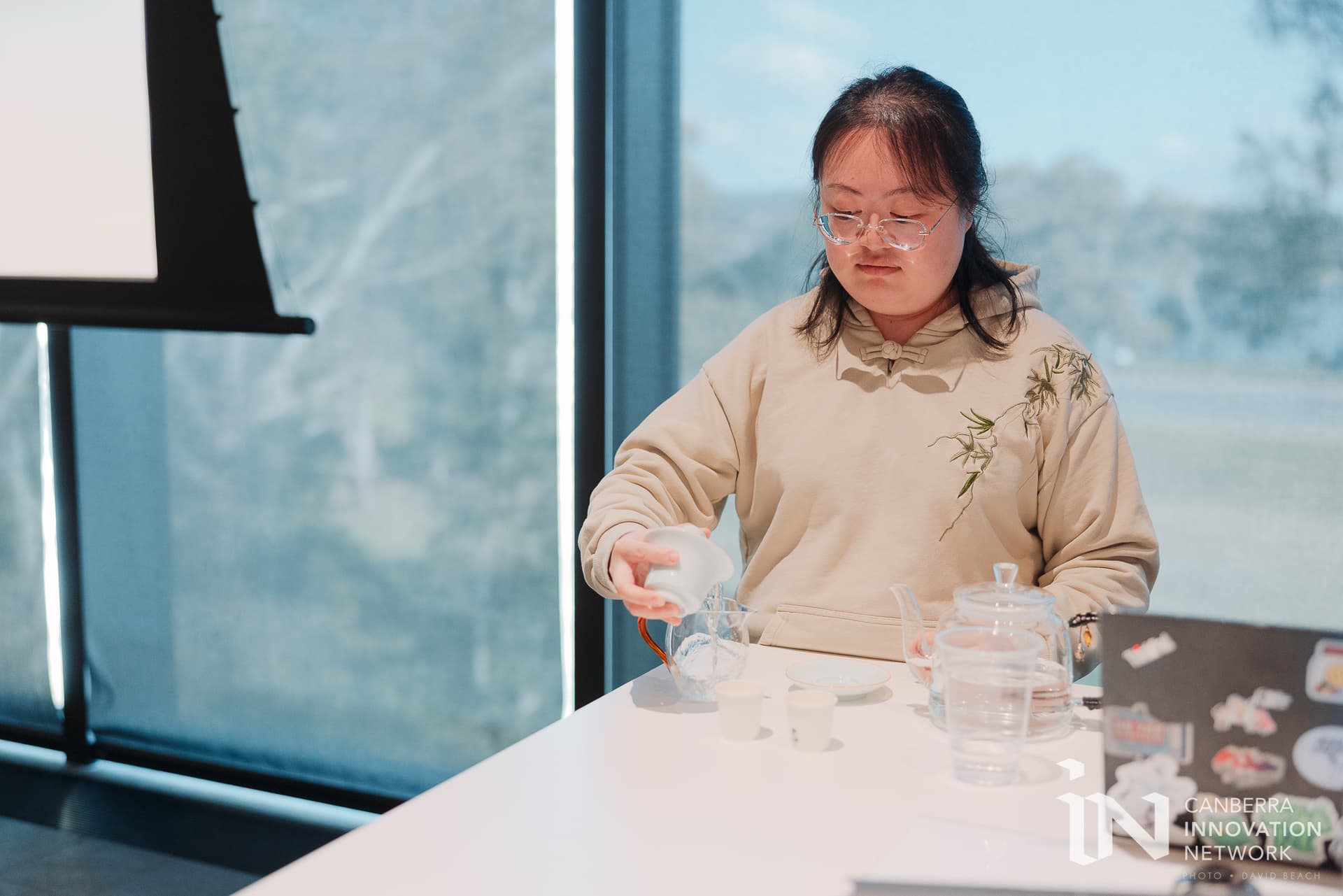 YEAF Co-founder, Xiaohan Xue, preparing tea live during the InnovationACT final pitch event at ANU Research School of Physics Auditorium (September 2026). Photo: David Beach.